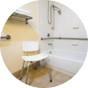 Assistive equipment in a bathroom including grab bars and a shower chair