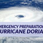 Blog post header with background image of a hurricane storm cloud from a distance. Over the image is a text box with dark red words: Emergency Preparations Hurricane Dorian