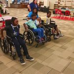 Campers tried a variety of assistive technology during camp, including wheelchairs. This group is mid-race for their wheelchair race.