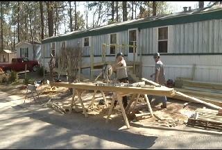 Volunteers build a ram on to a mobile home to make it accessible.